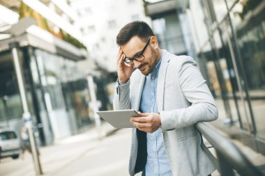 Ofis Binası tarafından dijital tablet ile yakışıklı genç işadamı