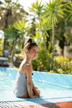 Sevimli küçük kız ve havuz kenarı gün güneşli yaz