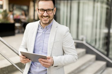 Ofis Binası tarafından dijital tablet ile yakışıklı genç işadamı