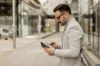Ofis Binası tarafından dijital tablet ile yakışıklı genç işadamı