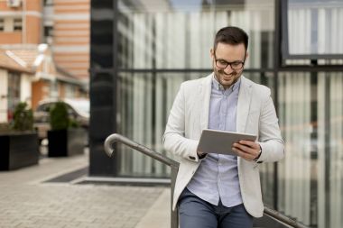 Ofis Binası tarafından dijital tablet ile yakışıklı genç işadamı