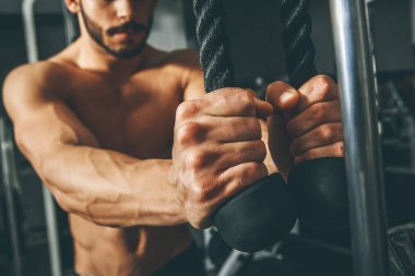 Çıplak gövde kaslı adam egzersizleri triceps ip ile yapıyor spor salonunda egzersiz