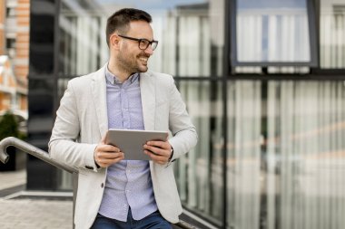 Ofis Binası tarafından dijital tablet ile yakışıklı genç işadamı