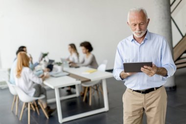 Elinde dijital tablet ile ayakta üst düzey işadamı portresi