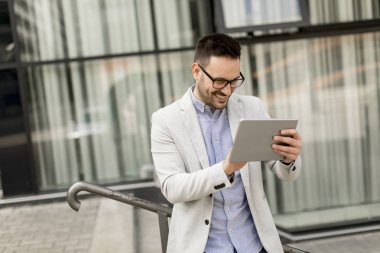 Ofis Binası tarafından dijital tablet ile yakışıklı genç işadamı