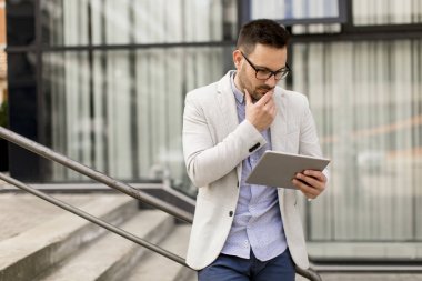 Ofis Binası tarafından dijital tablet ile yakışıklı genç işadamı