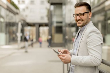 Ofis Binası tarafından dijital tablet ile yakışıklı genç işadamı