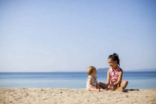 Śliczne Małe Siostry Siedząc Plaży Lato — Zdjęcie stockowe