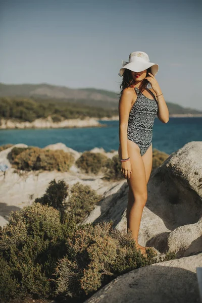 Güneşli bir gün taşlı plaj genç ve güzel kadın