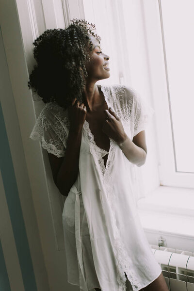 Pretty young african american woman posing in the room by the window