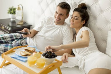 Genç sevgili çift yatakta kahvaltı