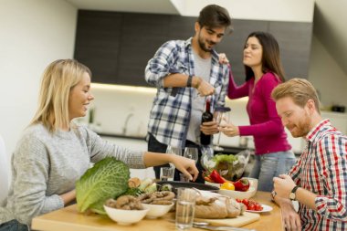 Bir grup genç insan odasında masasının kırmızı şarap içme