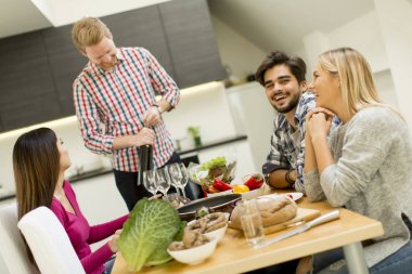 Bir grup genç insan odasında masasının kırmızı şarap içme