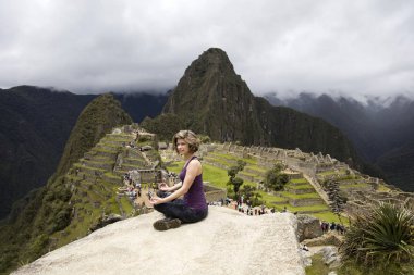 Genç kadın Peru Machu Picchu Inca Kalesi üzerinde meditasyon