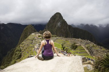 Genç kadın Peru Machu Picchu Inca Kalesi üzerinde meditasyon