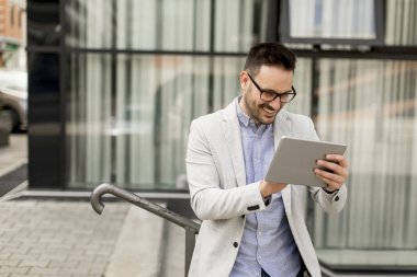 Ofis Binası tarafından dijital tablet ile yakışıklı genç işadamı