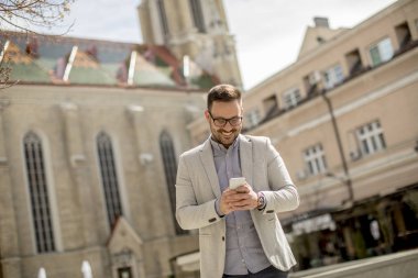 Dijital tablet kentsel ortamda açık tutan bir genç işadamı portresi