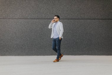 Yürüyüş ve cep telefonu açık konuşurken genç adam