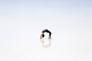 Köprü poz Salar de uyuni adlı genç kadın düz Bolivya'daki tuz