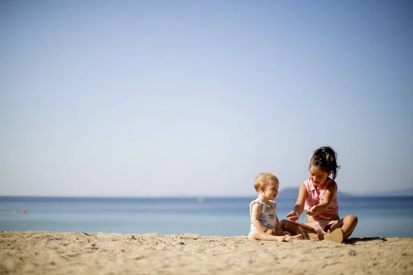 Śliczne Małe Siostry Siedząc Plaży Lato — Zdjęcie stockowe