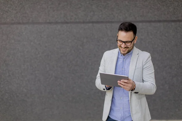 Joven Hombre Negocios Guapo Con Tableta Digital Por Pared Gris — Foto de Stock