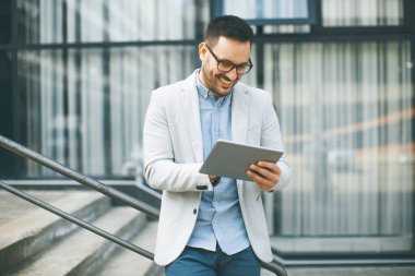 Ofis Binası tarafından dijital tablet ile yakışıklı genç işadamı