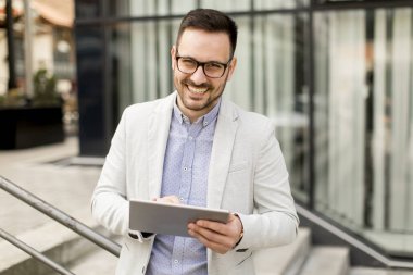 Ofis Binası tarafından dijital tablet ile yakışıklı genç işadamı