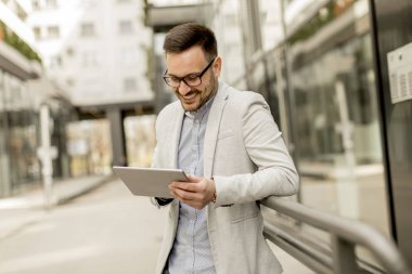 Ofis Binası tarafından dijital tablet ile yakışıklı genç işadamı