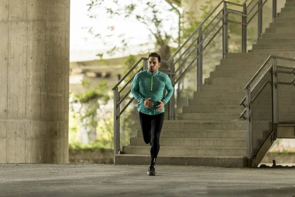 Hızlı açık havada şehirde koşan genç adam