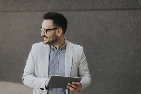 Joven Hombre Negocios Guapo Con Tableta Digital Por Pared Gris — Foto de Stock