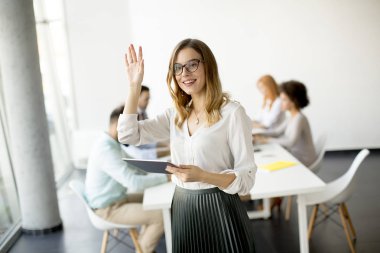 Genç çekici kadın Yöneticisi duran modern Office dijital tablet üzerinde çalışan