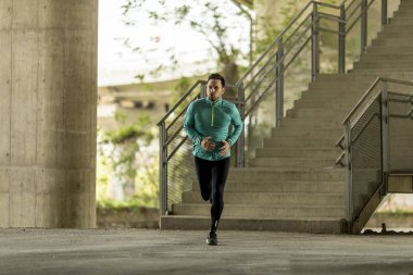 Hızlı açık havada şehirde koşan genç adam