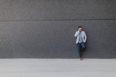 Genç adam cep telefonu el ile duvar tarafından açık duran