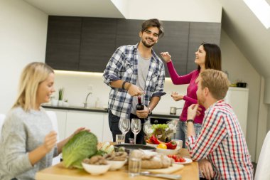 Bir grup genç insan odasında masasının kırmızı şarap içme