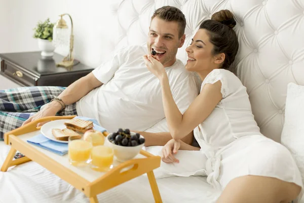 Genç sevgili çift yatakta kahvaltı