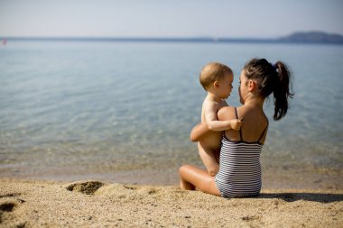 Sevimli küçük kız yaz sahilde oturmuş