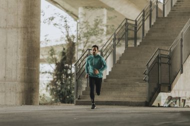 Hızlı açık havada şehirde koşan genç adam