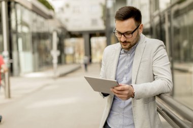 Ofis Binası tarafından dijital tablet ile yakışıklı genç işadamı