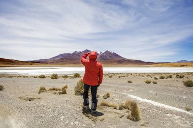 Genç adam lookinag lagün ve Eduardo Avaroa and Fauna Ulusal rezerv Bolivya, dağlar