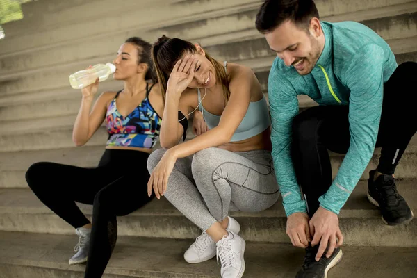 Portrait of young runners resting on stairs after the training