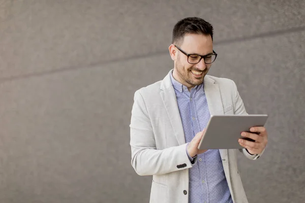 Joven Hombre Negocios Guapo Con Tableta Digital Por Pared Gris — Foto de Stock