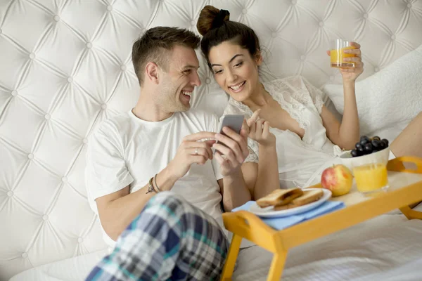 Amante Casal Tomando Café Manhã Cama Olhando Para Telefone Móvel — Fotografia de Stock