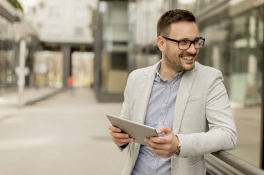 Ofis Binası tarafından dijital tablet ile yakışıklı genç işadamı
