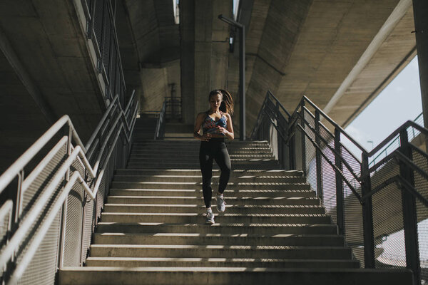 Young woman running alone down stairs  outdoor in urban environment