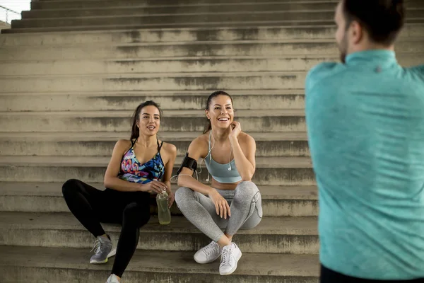 Portrait of young runners resting on stairs after the training