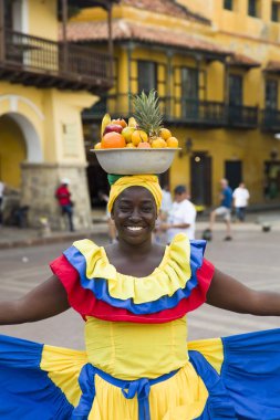 Cartagena, Kolombiya - 16 Eylül 2019: tanımlanamayan palenquera, Cartagena, Kolombiya sokaklarındaki meyve satıcısı kadın. Bu Afro-Kolombiyalı kadınlar şehrin hemen dışındaki San Basilio de Palenque köyünden geliyorlar..