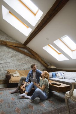 Evde tablet kullanan mutlu genç çift.