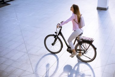 Modern şehir elektrikli e-motorlu güzel genç kadın temiz sürdürülebilir şehir ulaşımı