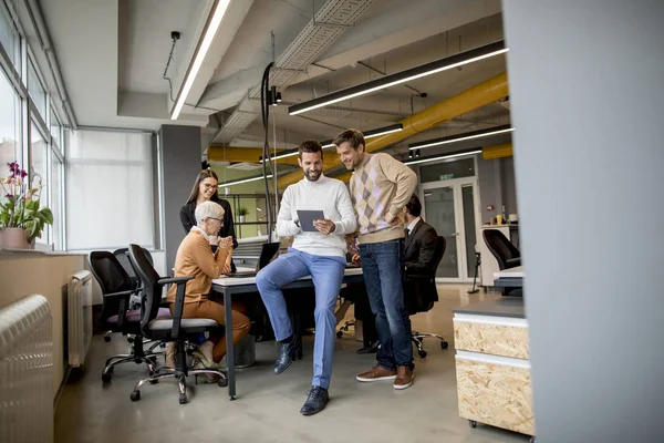 Два бизнесмена с цифровым планшетом в современном офисе — стоковое фото