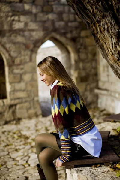 Jolie Jeune Femme Assise Sur Banc Regardant Des Feuilles Jaunes — Photo